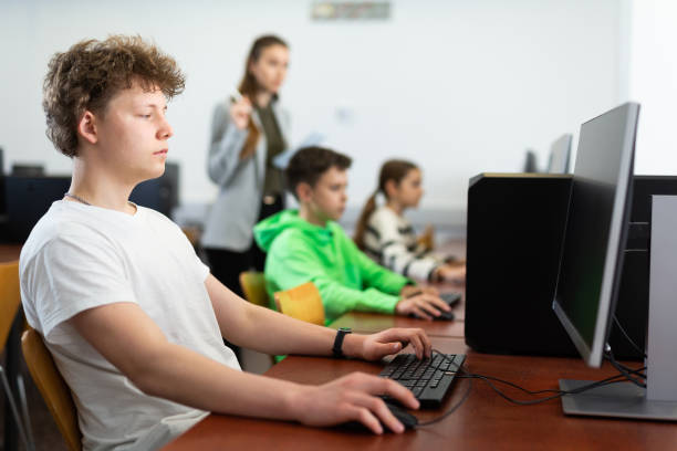 teenager boy using pc during computer science lesson - 電競(jìng)教育 個(gè)照片及圖片檔